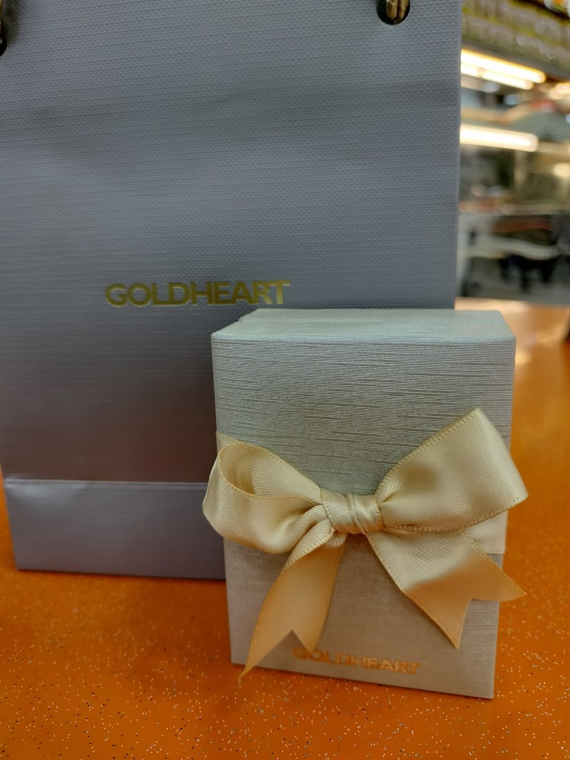 An elegant Goldheart jewelry gift box with a ribbon and a branded shopping bag.