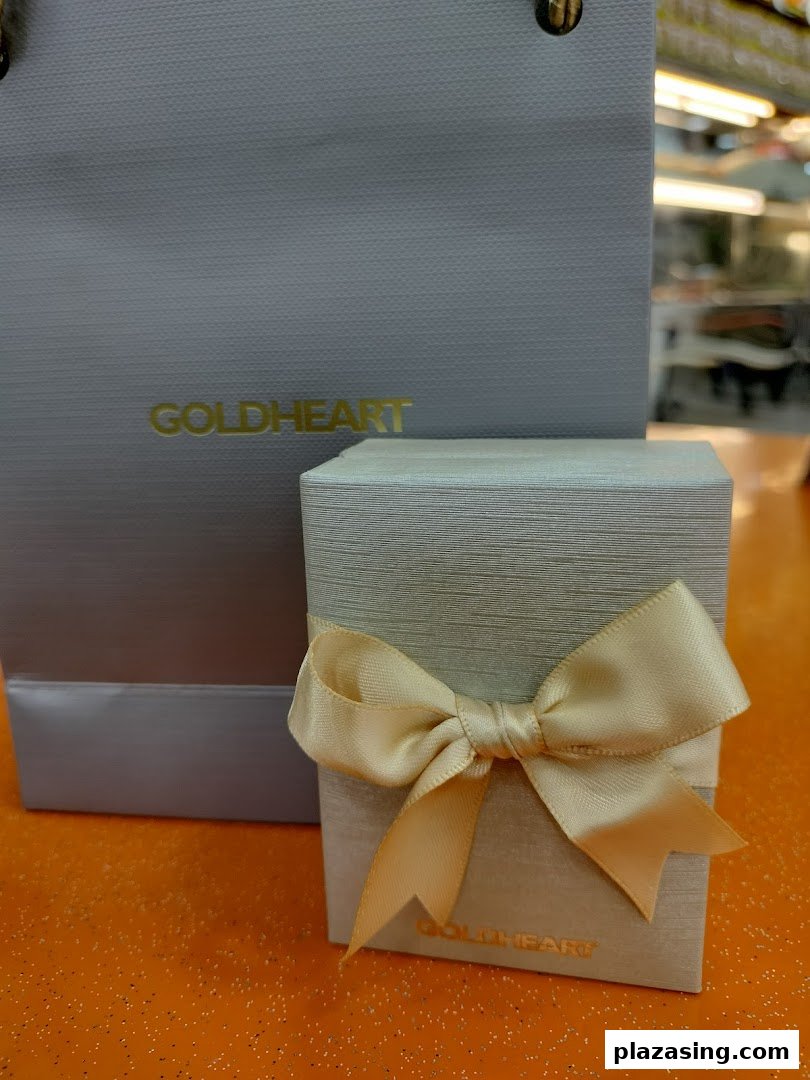 An elegant Goldheart jewelry gift box with a ribbon and a branded shopping bag.