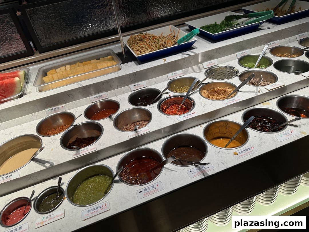 A vibrant self-service condiment and sauce bar at Haidilao Hot Pot, featuring various ingredients for custom dipping sauces.