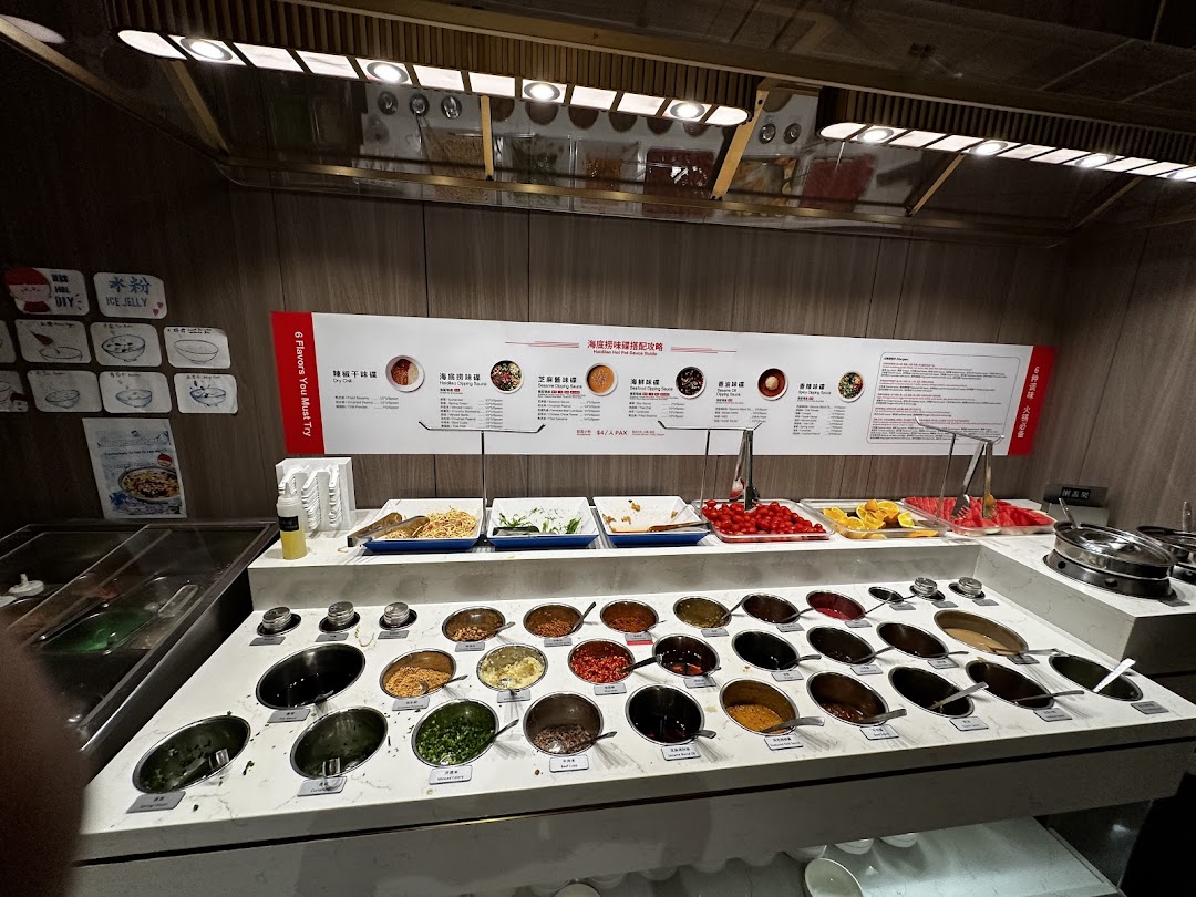A vibrant self-service sauce and condiment bar at Haidilao Hot Pot, featuring fresh ingredients and custom mixes.