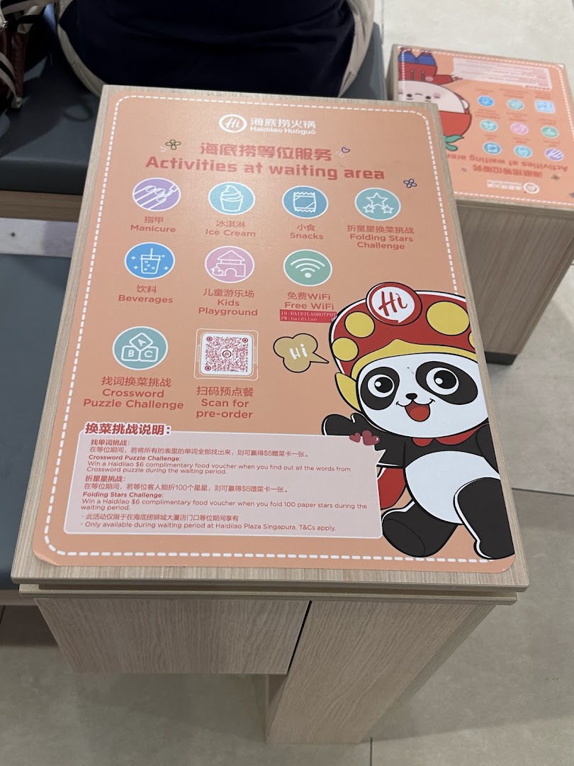 A sign detailing complimentary activities and challenges available in Haidilao's waiting area.