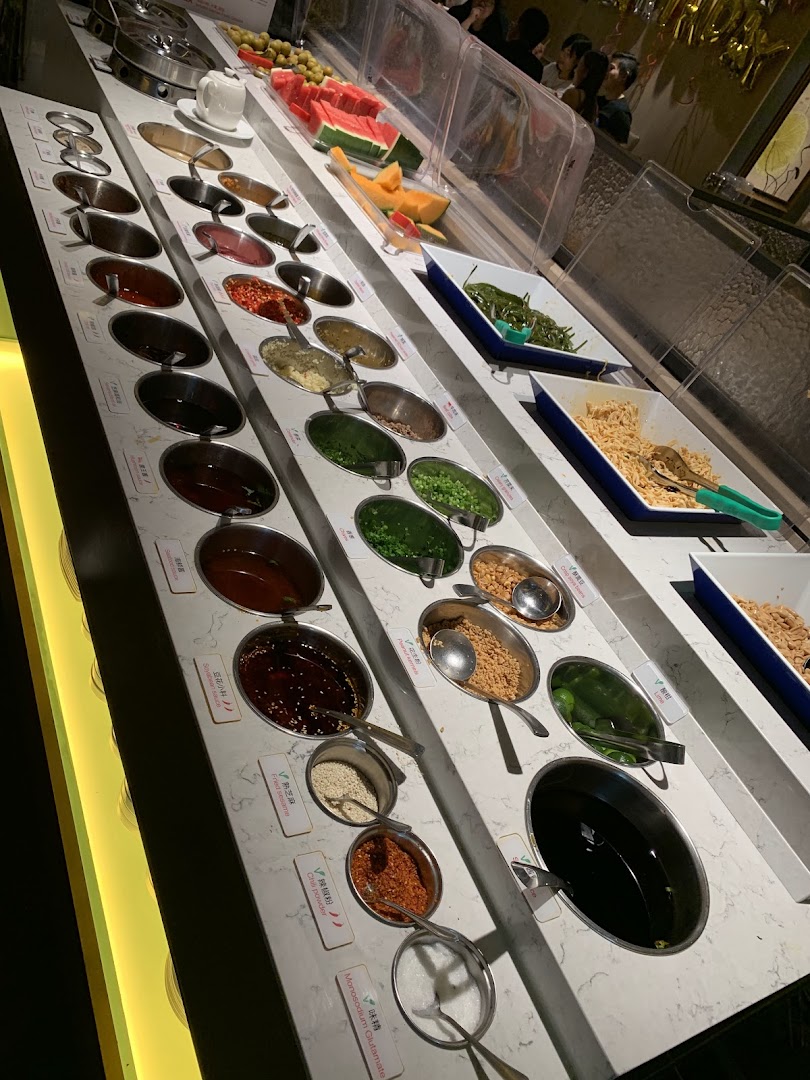 A vibrant self-service bar featuring a wide array of sauces, condiments, and fresh fruits.