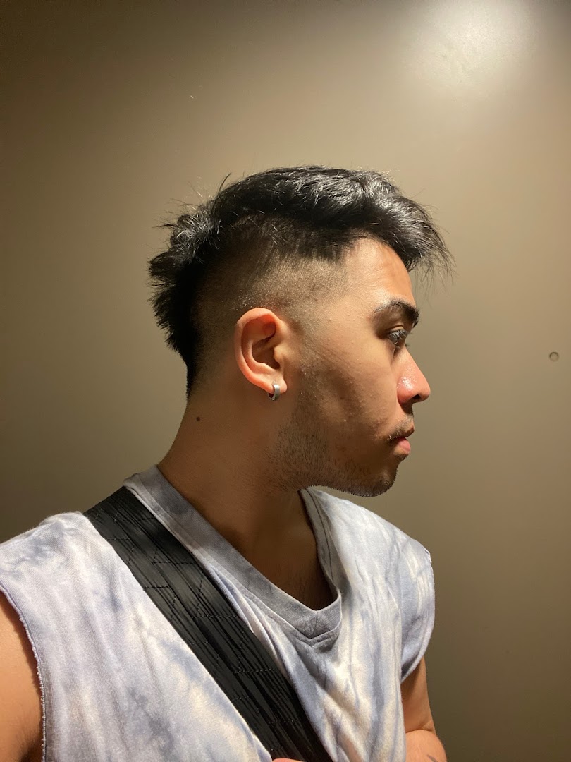 Close-up of a person showcasing a fresh, modern haircut with a fade and textured top.
