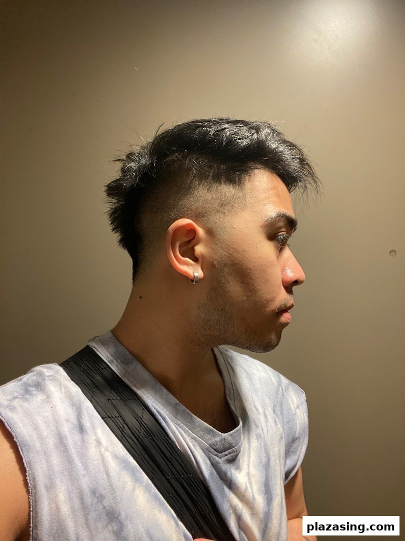 Close-up of a person showcasing a fresh, modern haircut with a fade and textured top.