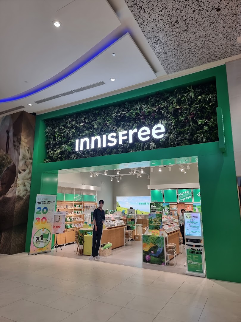 The vibrant green storefront of Innisfree, showcasing its natural aesthetic and inviting entrance.