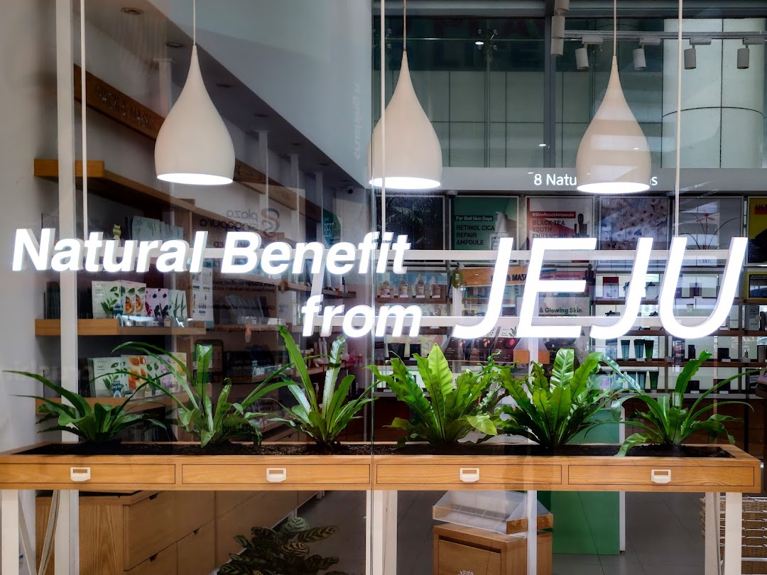 Innisfree shop front featuring 'Natural Benefit from JEJU' text and a planter box with green plants.