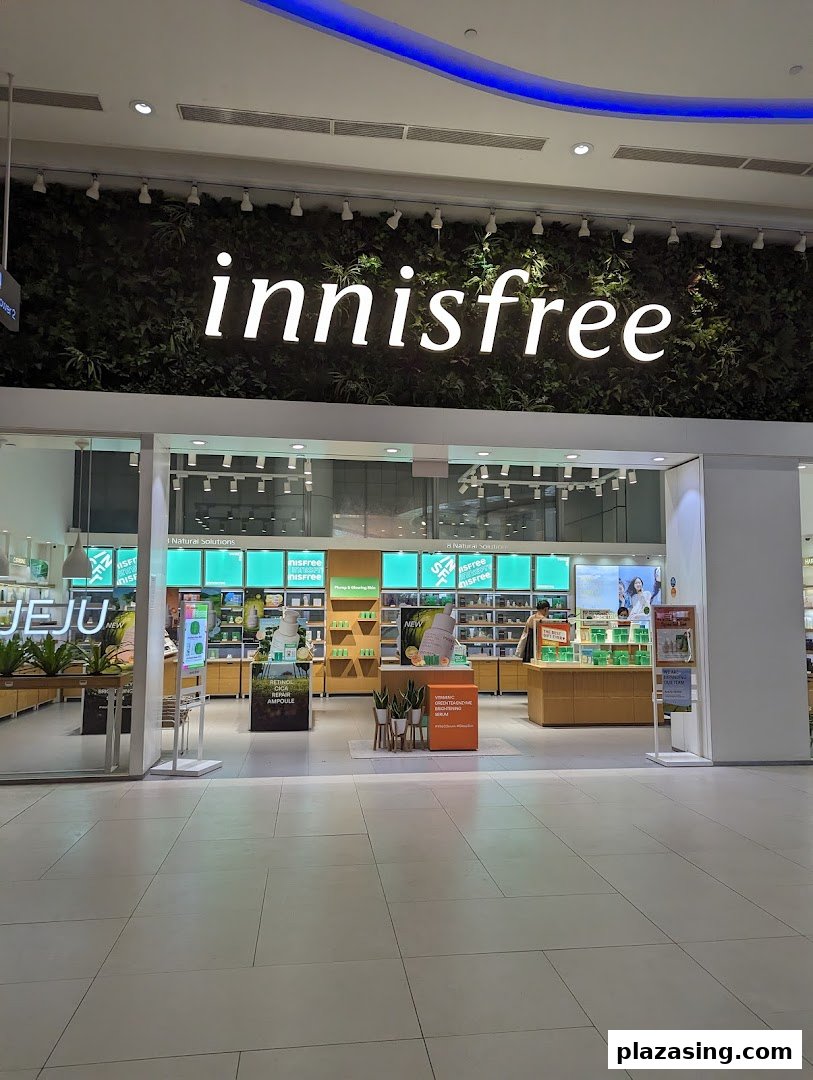 The innisfree shop entrance features a green wall with its logo, showcasing a bright, natural-themed interior.