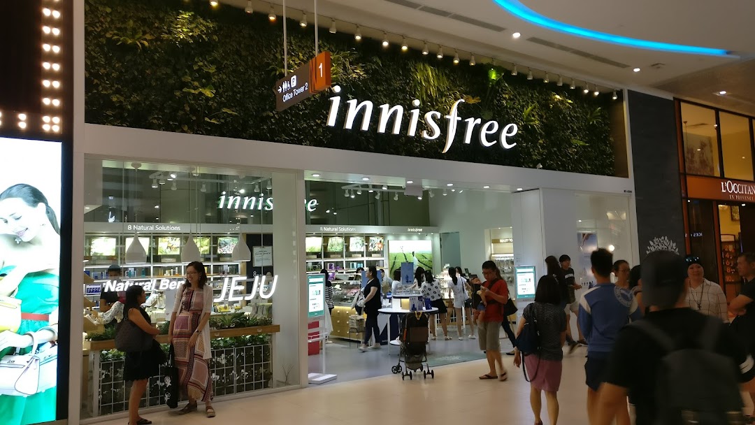 The innisfree shop front with a distinctive green wall, showcasing its natural beauty concept.