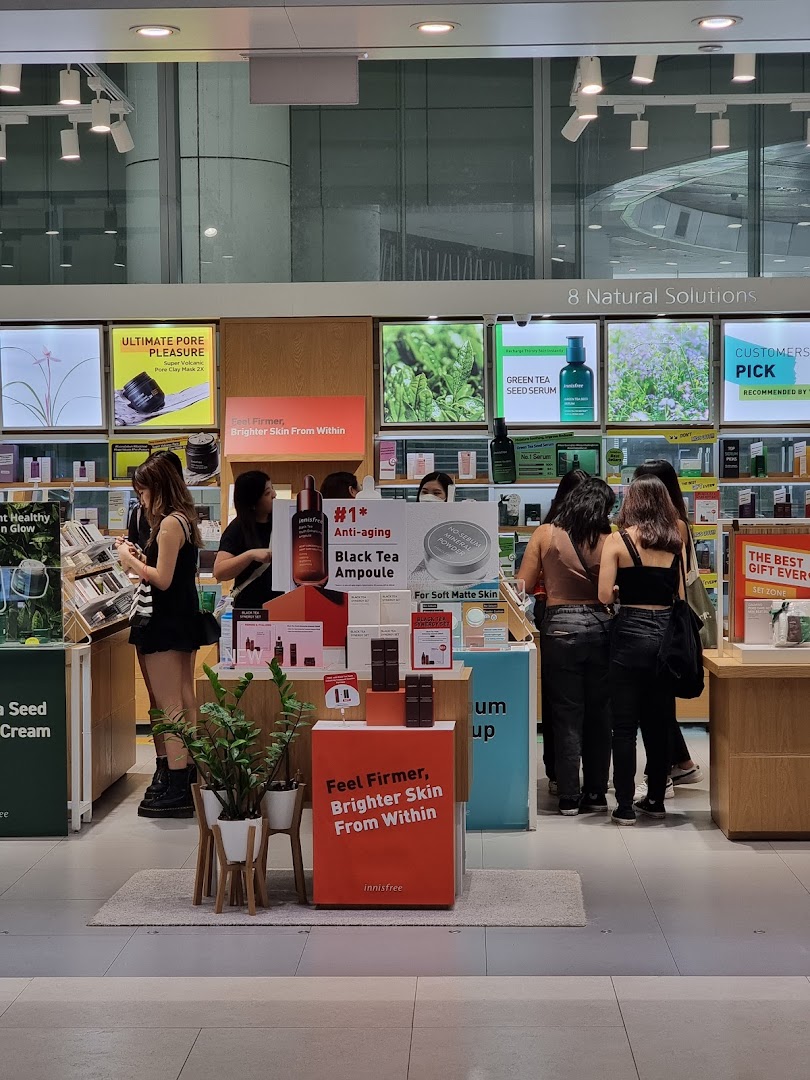 Customers browse natural skincare products and displays inside the Innisfree shop.