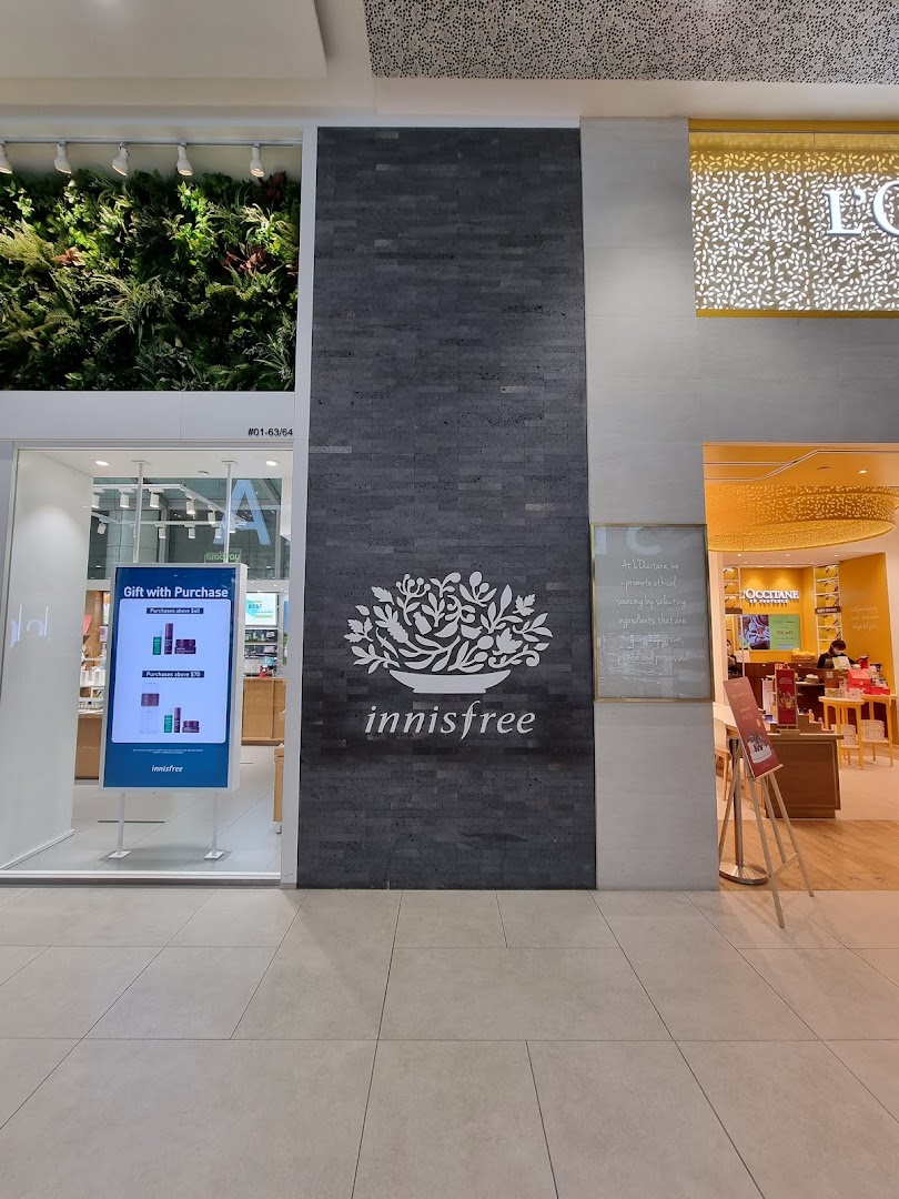 The innisfree shop front features its distinctive logo, a lush green wall, and an inviting entrance.