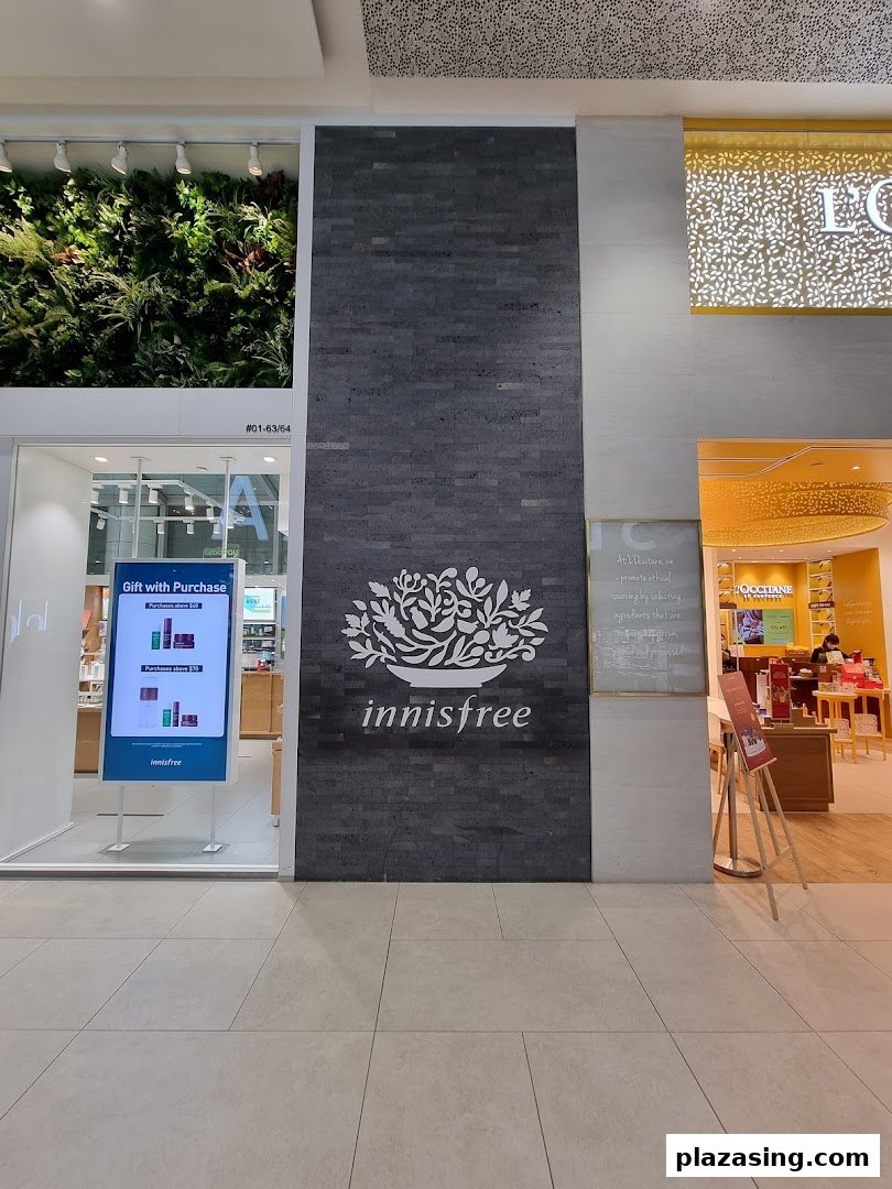The innisfree shop front features its distinctive logo, a lush green wall, and an inviting entrance.