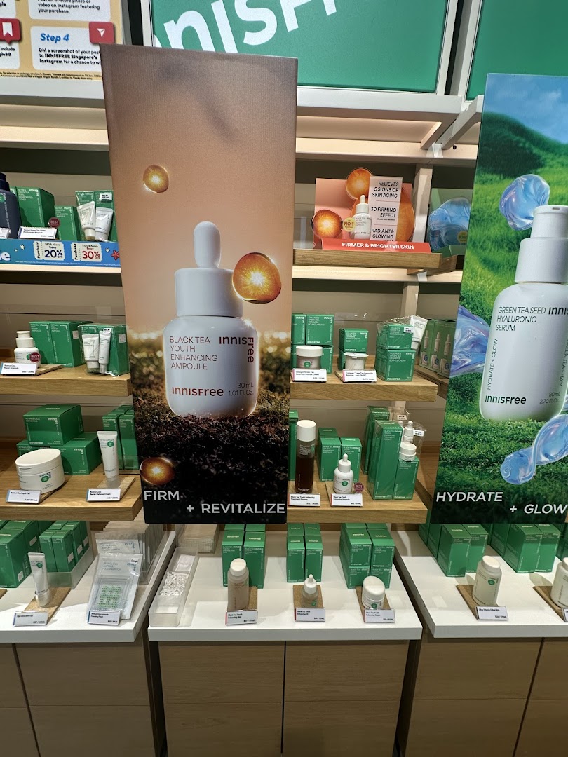 Innisfree skincare products, including ampoules and serums, displayed on shelves with promotional signage.