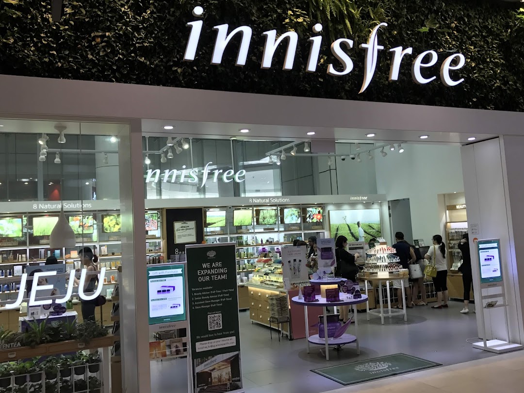 Brightly lit entrance of Innisfree beauty store, showcasing natural skincare products and inviting customers.
