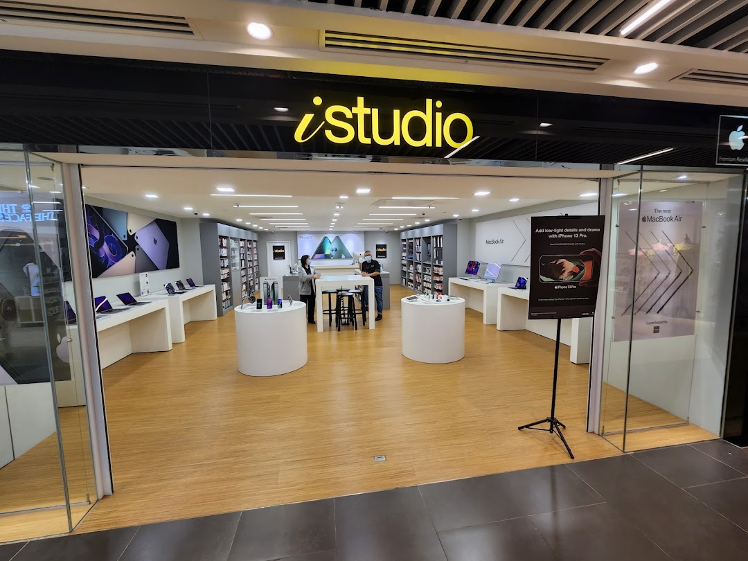 The storefront of iStudio, an Apple Premium Reseller, showcasing various Apple products and a clean interior.