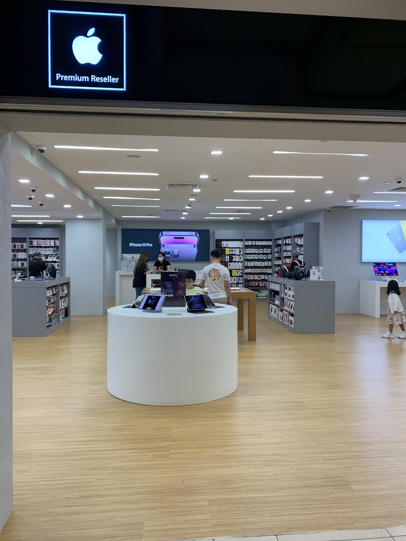 Entrance view of iStudio, an Apple Premium Reseller, showcasing various Apple products and customers browsing.