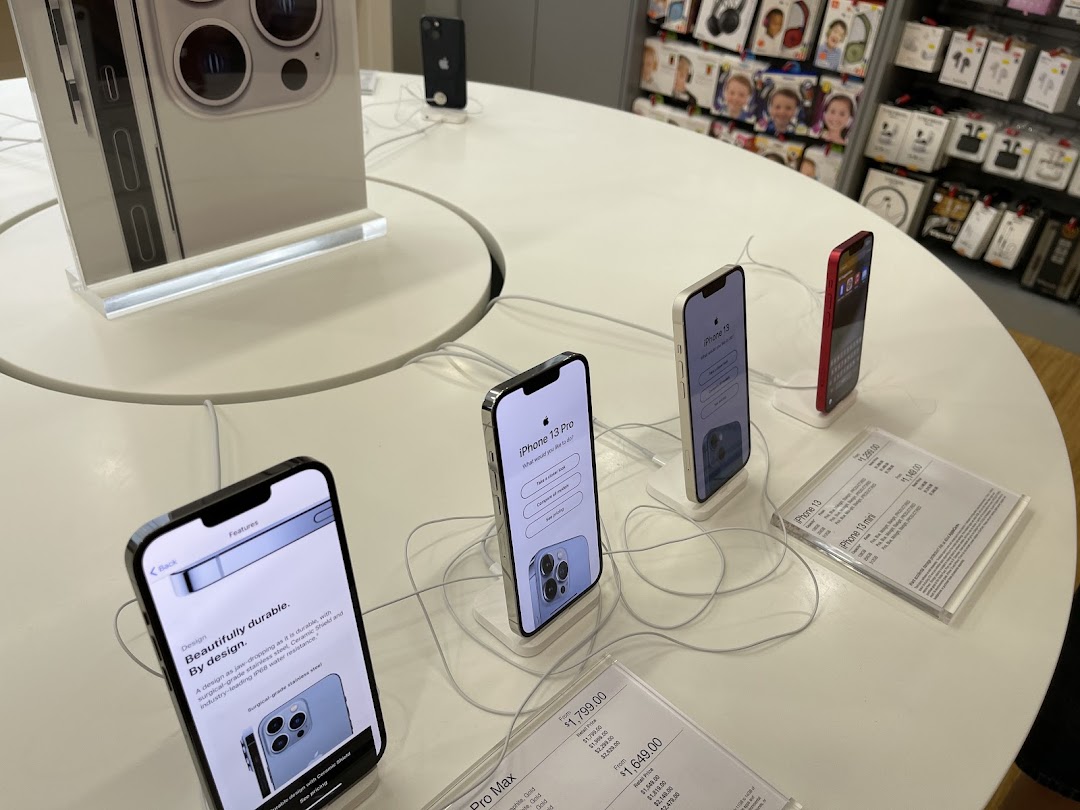 iPhones and accessories displayed on a circular table inside iStudio Plaza Singapura.