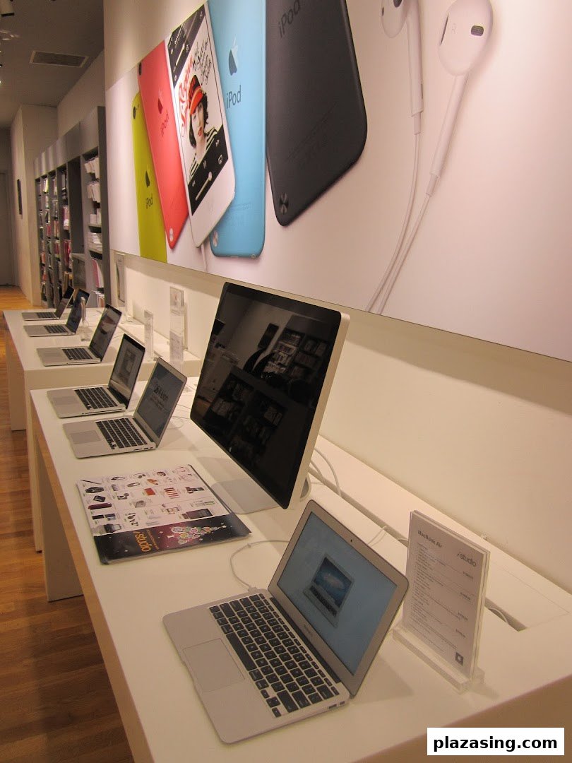 Modern iStudio interior showcasing Apple products like MacBooks, iMacs, and iPods on display.