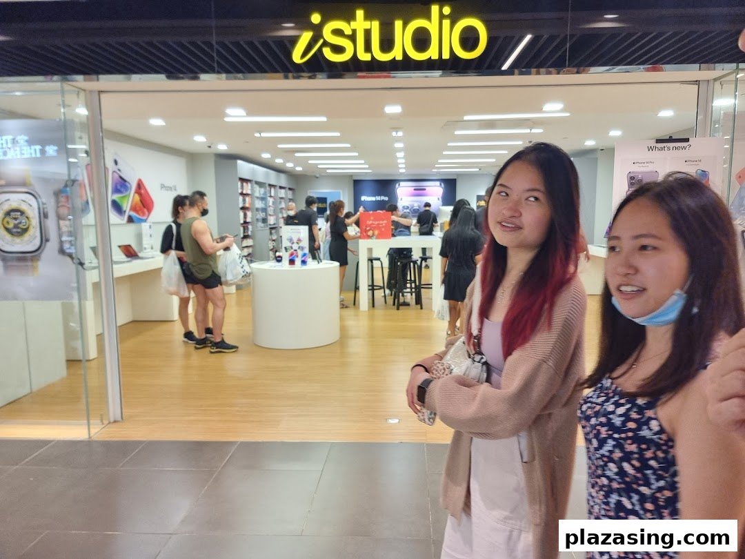 The iStudio shop entrance at Plaza Singapura, showcasing Apple products and inviting customers inside.