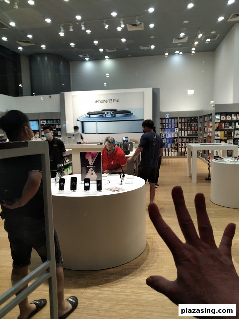 Inside iStudio Plaza Singapura, customers browse Apple products and accessories in a modern retail space.