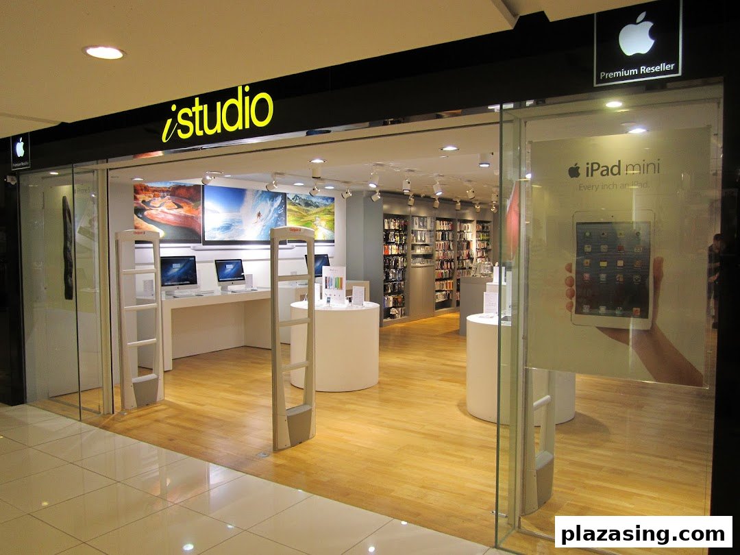 The storefront of iStudio, an Apple Premium Reseller, showcasing Apple products and a bright interior.