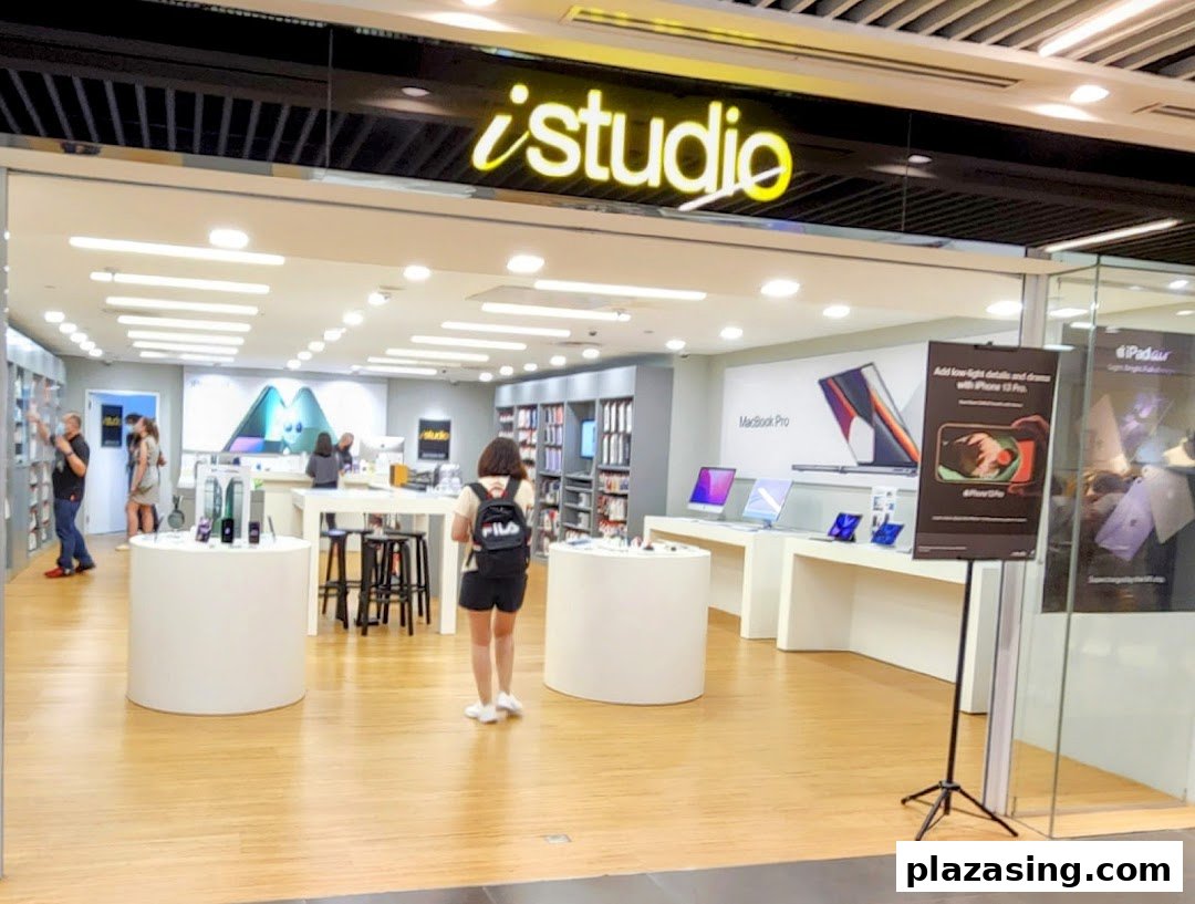 The iStudio shop front at Plaza Singapura, showcasing Apple products and a bright interior.