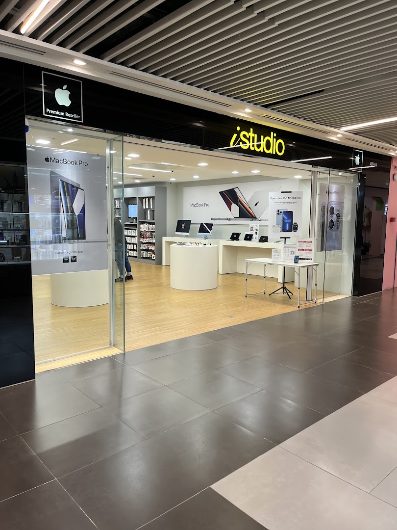 The storefront of iStudio, an Apple Premium Reseller, showcasing Apple products inside.