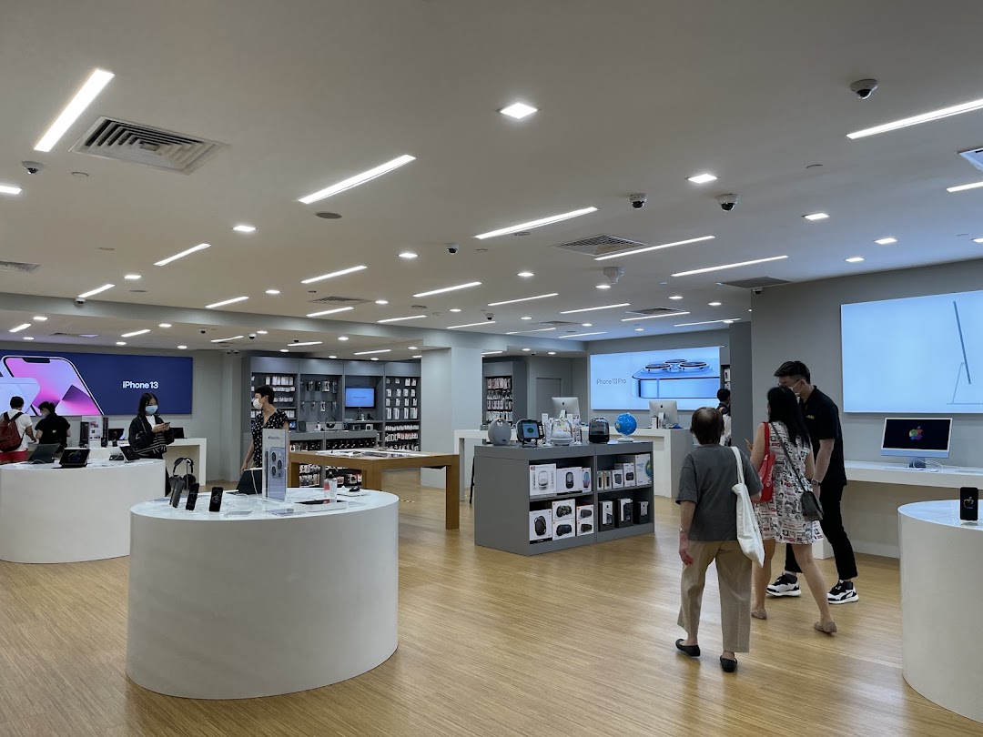 Customers browse Apple products and accessories in a brightly lit iStudio retail store.