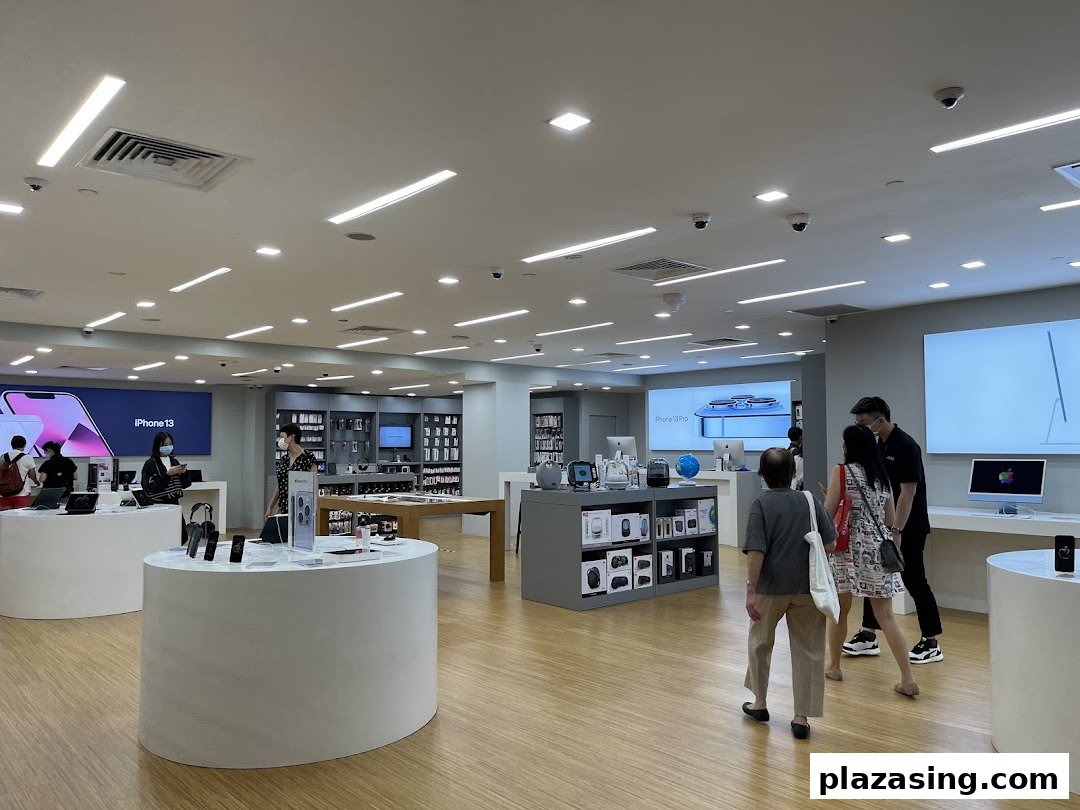 Customers browse Apple products and accessories in a brightly lit iStudio retail store.