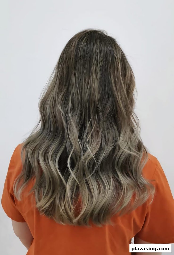 Back view of a person showcasing long, wavy hair with blonde and brown highlights.