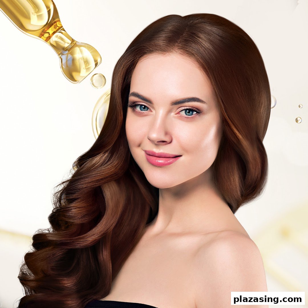 A smiling woman with long, healthy brown hair, with a dropper applying hair oil.