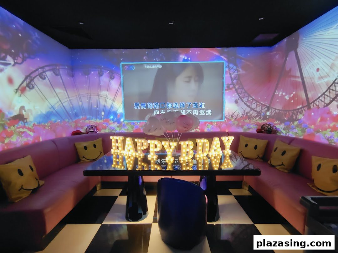 A vibrant KTV room with a large screen, colorful wall projections, and a 'Happy Bday' sign.