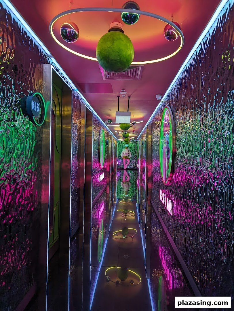 A vibrant, neon-lit hallway with reflective walls and unique decor leading to KTV rooms.