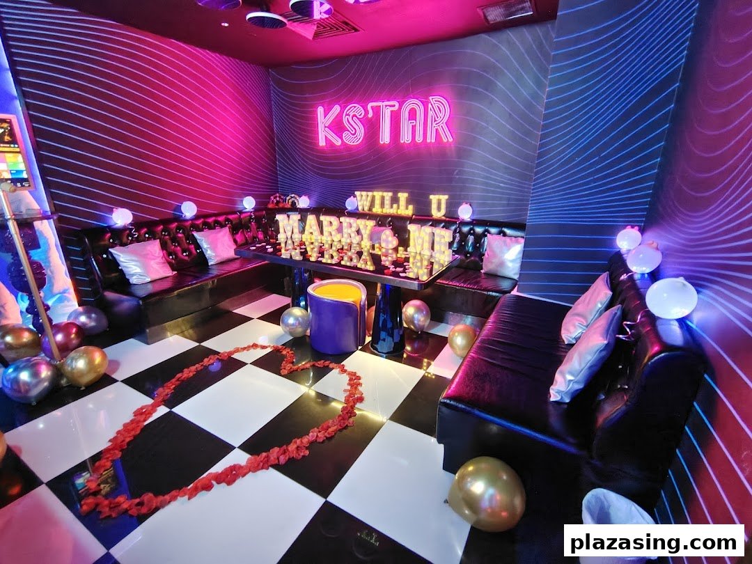 A vibrant KTV room decorated for a proposal with neon lights, balloons, and rose petals.