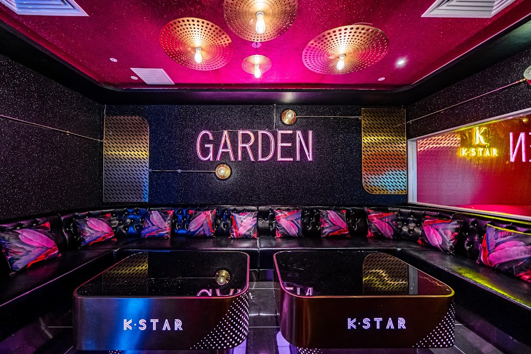 A vibrant KTV room at K.STAR with neon lights, comfortable seating, and modern decor.