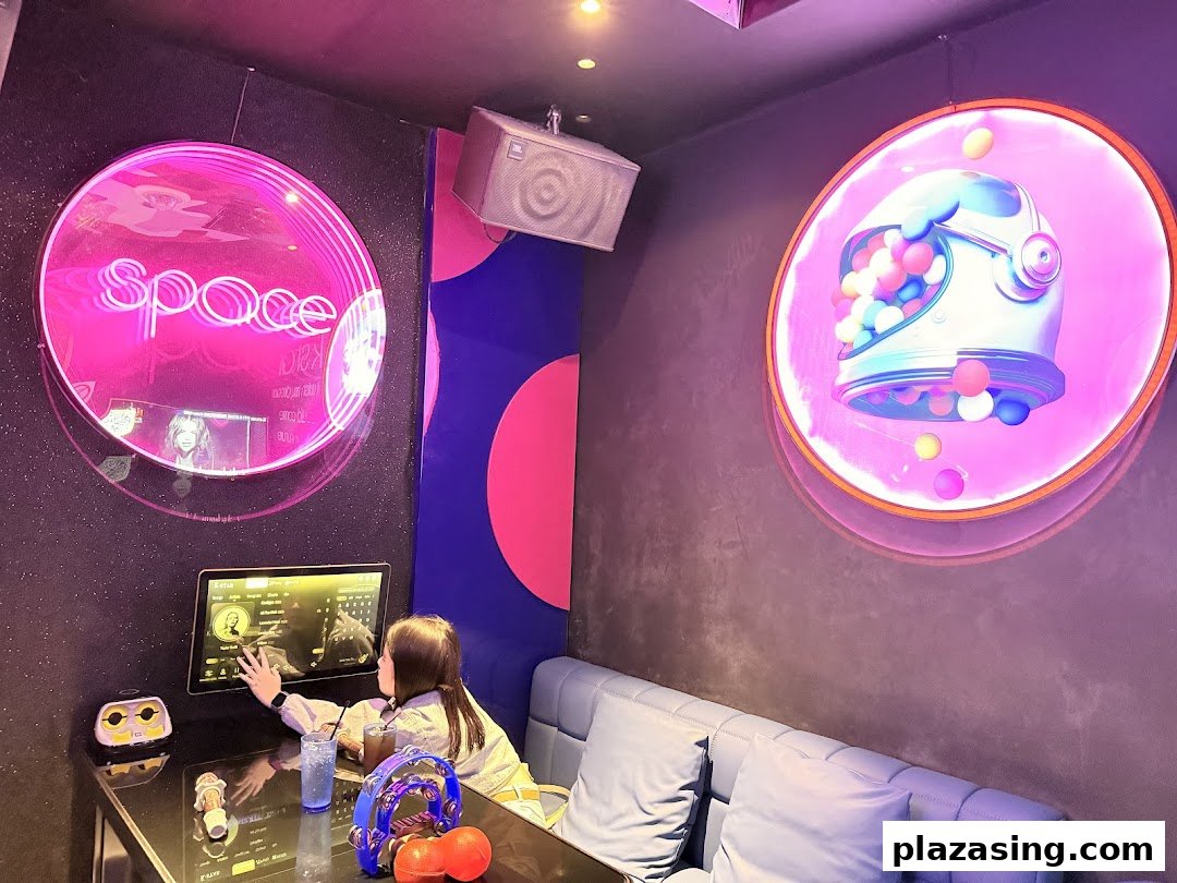 A person selecting songs in a vibrant, space-themed karaoke room at K.STAR.