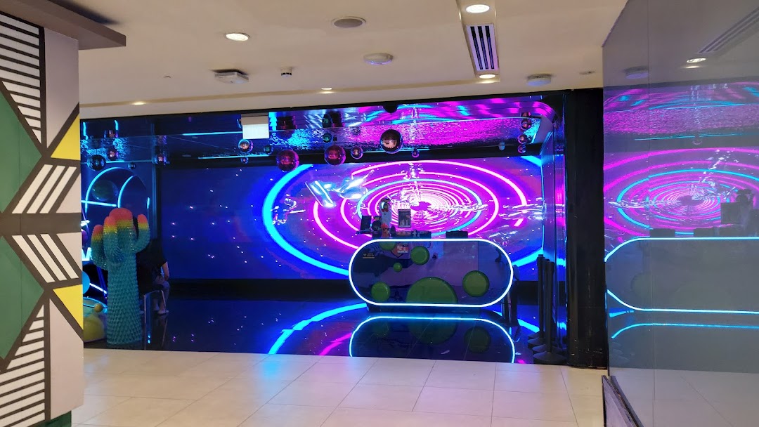 Vibrant, neon-lit entrance of K.STAR KTV with a large digital display and futuristic decor.