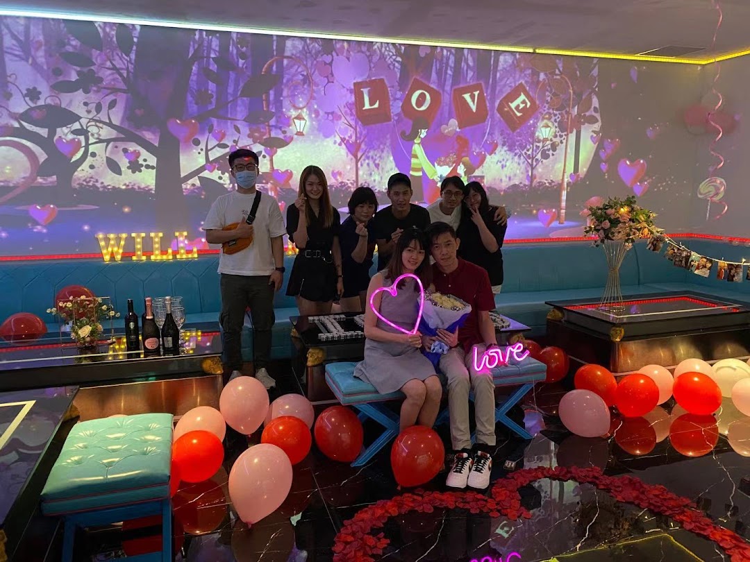 Friends celebrate a special occasion in a vibrant K.STAR KTV room with festive decorations.