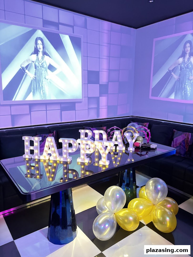 A vibrant KTV room with 'HAPPY BDAY' lights, balloons, and large screens displaying visuals.