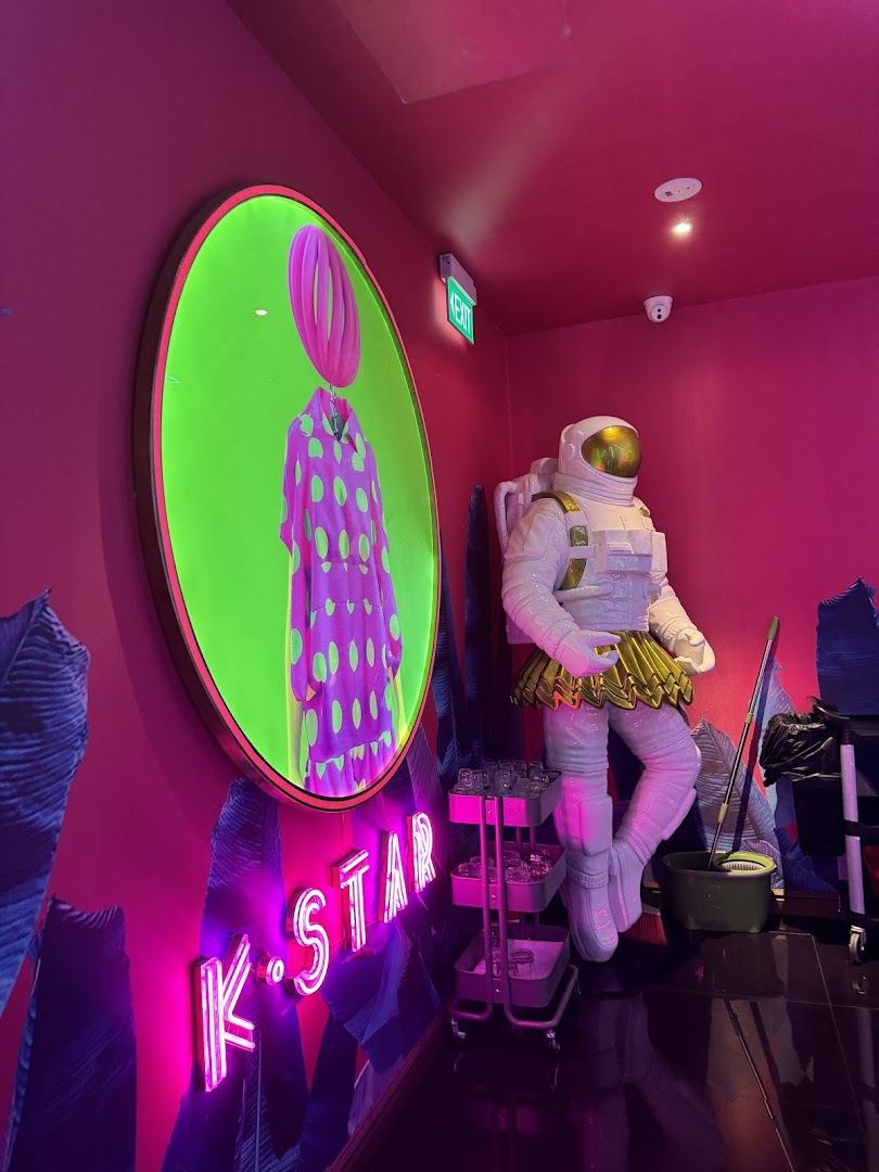Vibrant, neon-lit interior of K.STAR featuring an astronaut statue and unique circular art.
