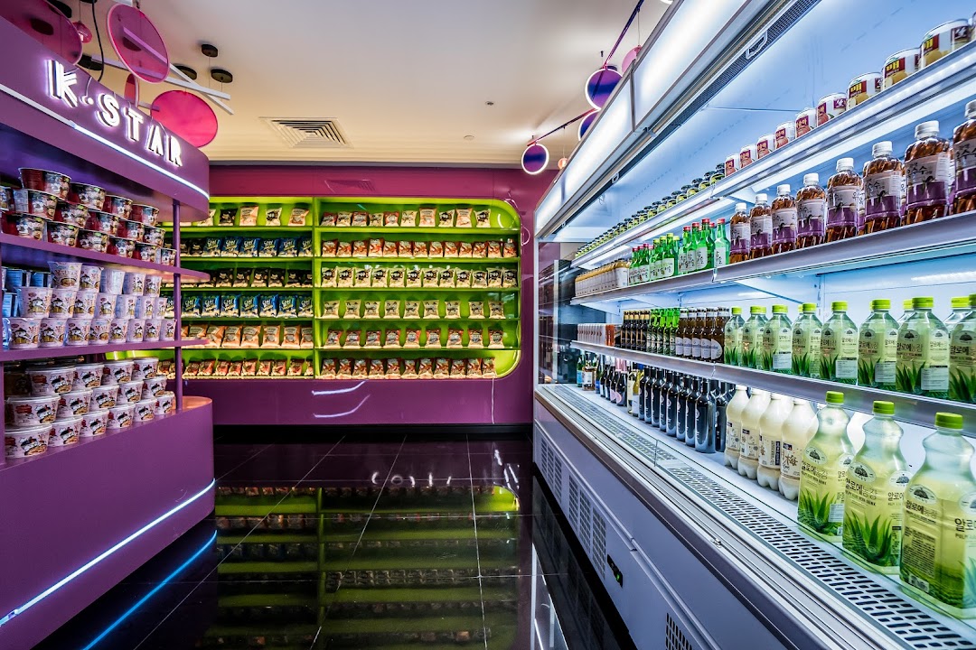 Vibrant interior of K.STAR, showcasing shelves of Korean instant noodles, snacks, and a wide selection of beverages.
