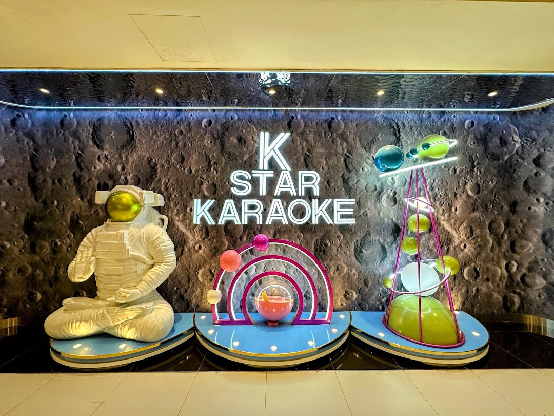 The K.STAR Karaoke shop front features a space-themed design with an astronaut and planets.