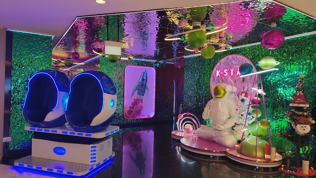 Vibrant, space-themed entertainment venue interior with VR pods and astronaut display.