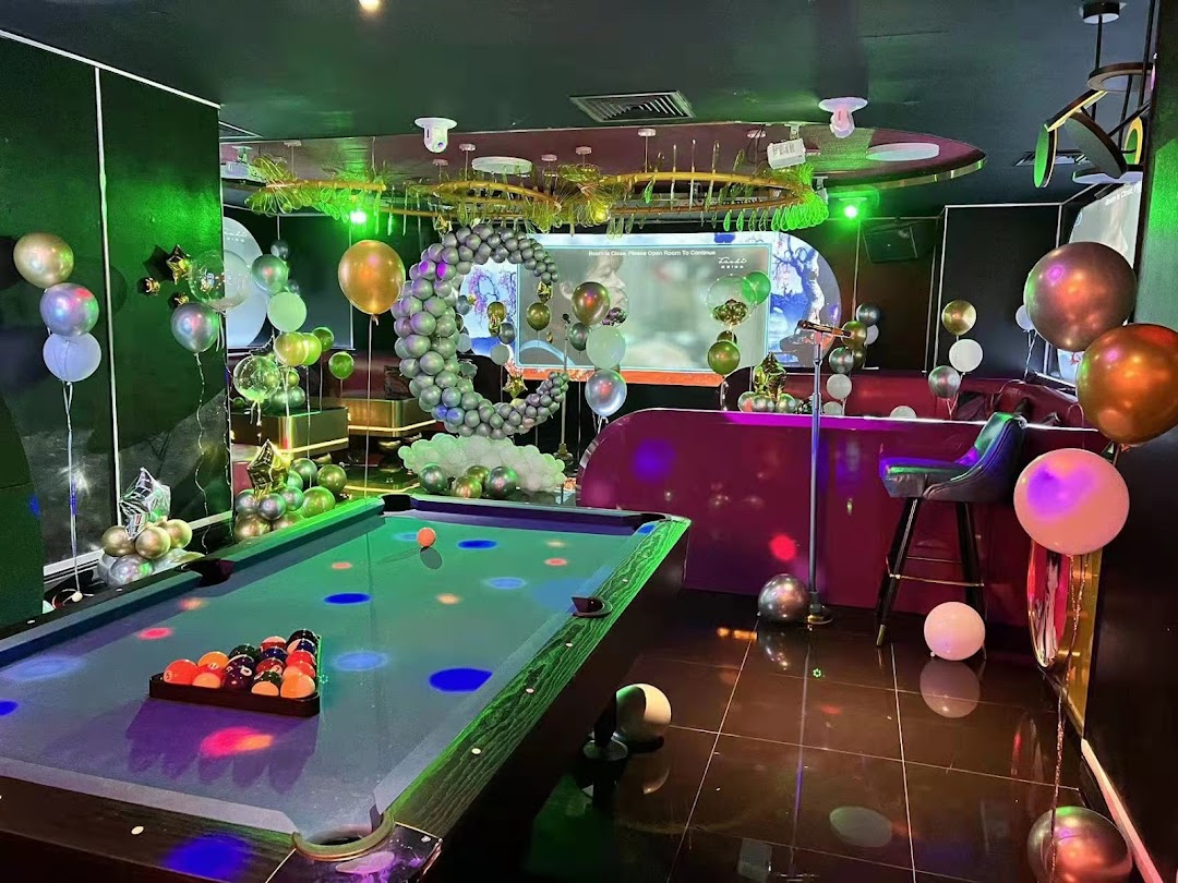 A vibrant KTV room with a pool table, colorful lighting, and festive balloon decorations.