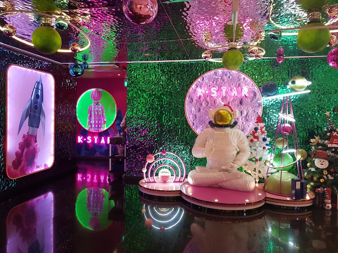 Vibrant, space-themed entrance display for K.STAR with an astronaut figure and neon lights.