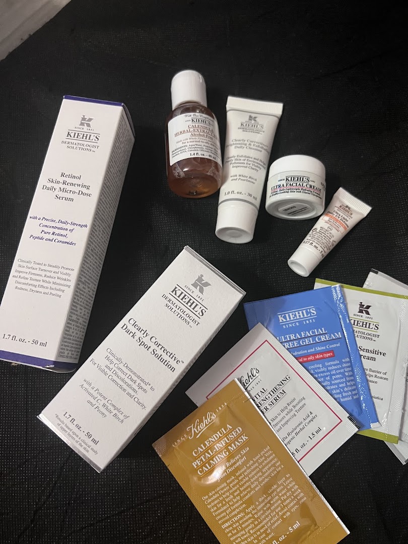A variety of Kiehl's skincare products, including serums, creams, and sample packets.
