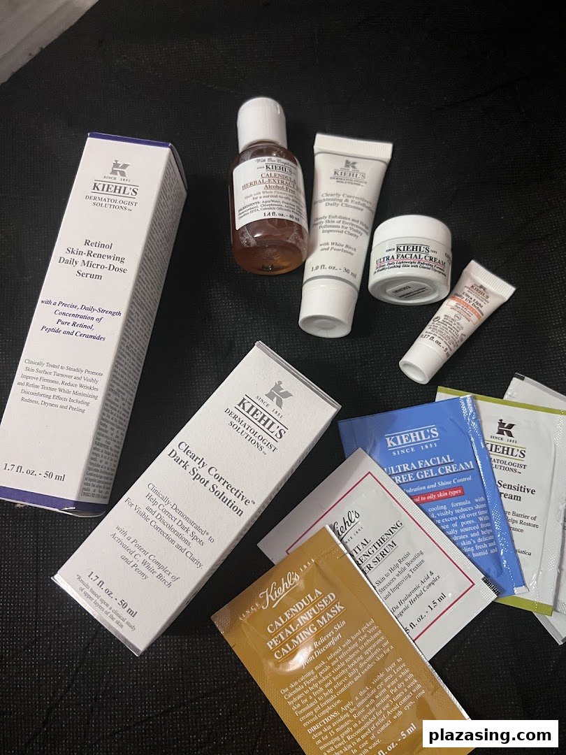 A variety of Kiehl's skincare products, including serums, creams, and sample packets.