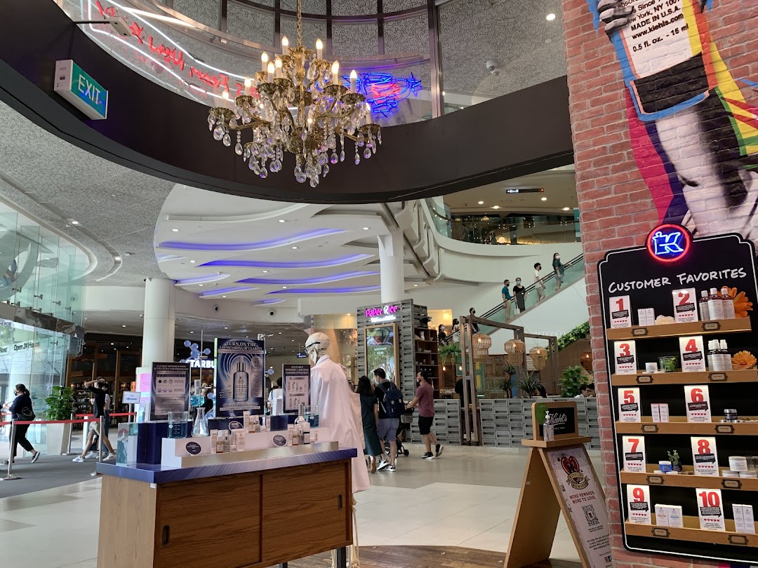A Kiehl's product display featuring skincare and customer favorites in a brightly lit shopping mall common area.