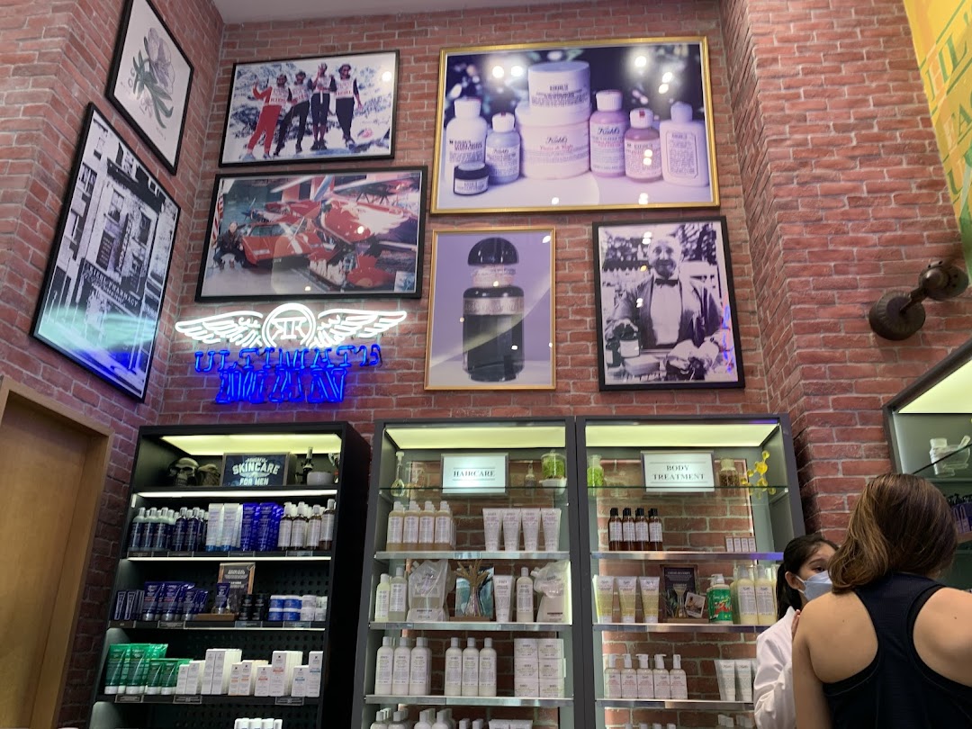 Interior view of Kiehl's store showcasing skincare products, display shelves, and vintage-inspired wall decor.