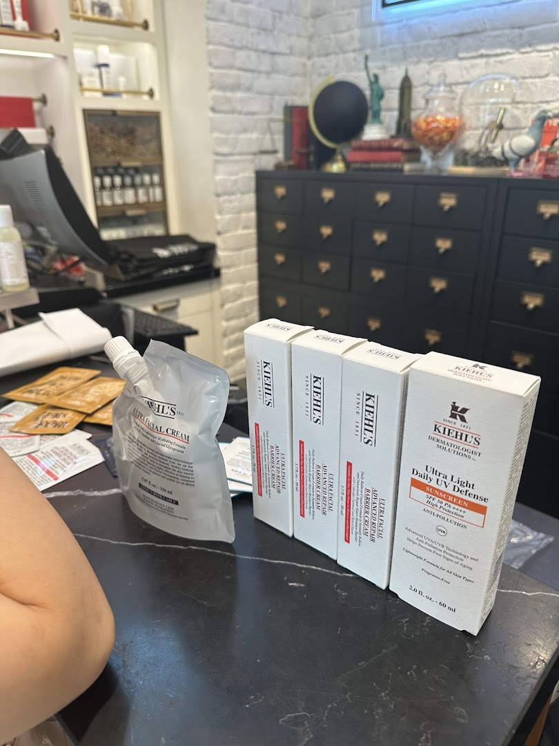 Kiehl's skincare products, including Ultra Facial Cream and UV Defense, displayed on a counter with shop interior.