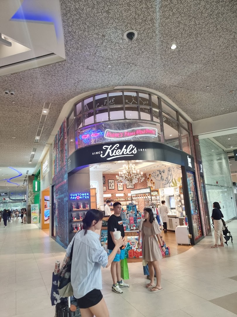 The Kiehl's Plaza Singapura shop front with customers and staff visible inside.